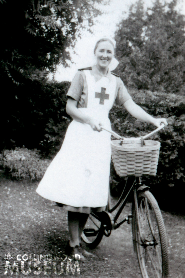 Photograph of woman standing with bicycle