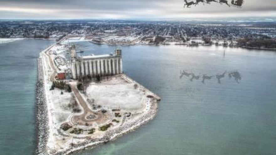 a snowy peninsula with santa and his reindeer flying above