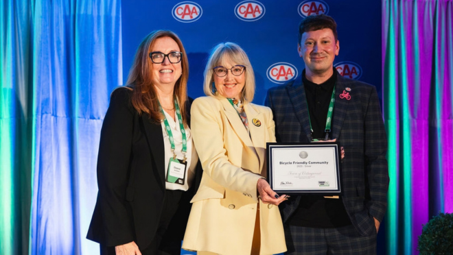 Councillor Doherty holding the Silver Designation award