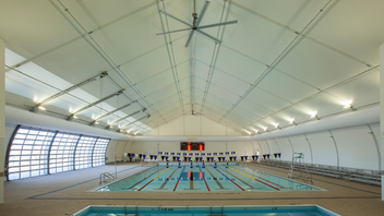 Collingwood's indoor swimming pool with multiple swim lanes and bleachers to the side.