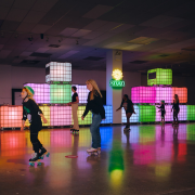 People roller skating with light up blocks behind them