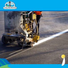 road line painting photo of a white line being painted on asphalt