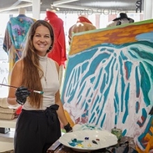 artist holding paint brush beside painting