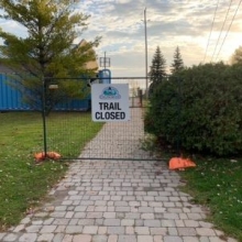 trail closed sign on temp fence