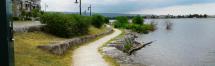 A photograph of a granular trail alongside the waterfront at the promenade.