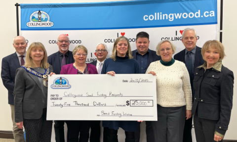 Group photo holding a large cheque for seed funding