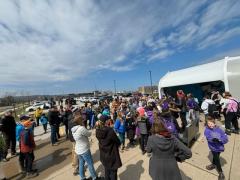 A group gathers outside in preparation for community clean up