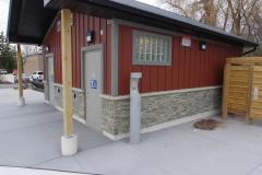 Grey water fountain against the side of an outdoor public washroom