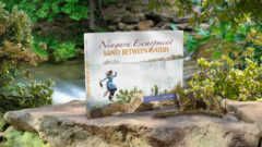 Land Between Waters book on a rock