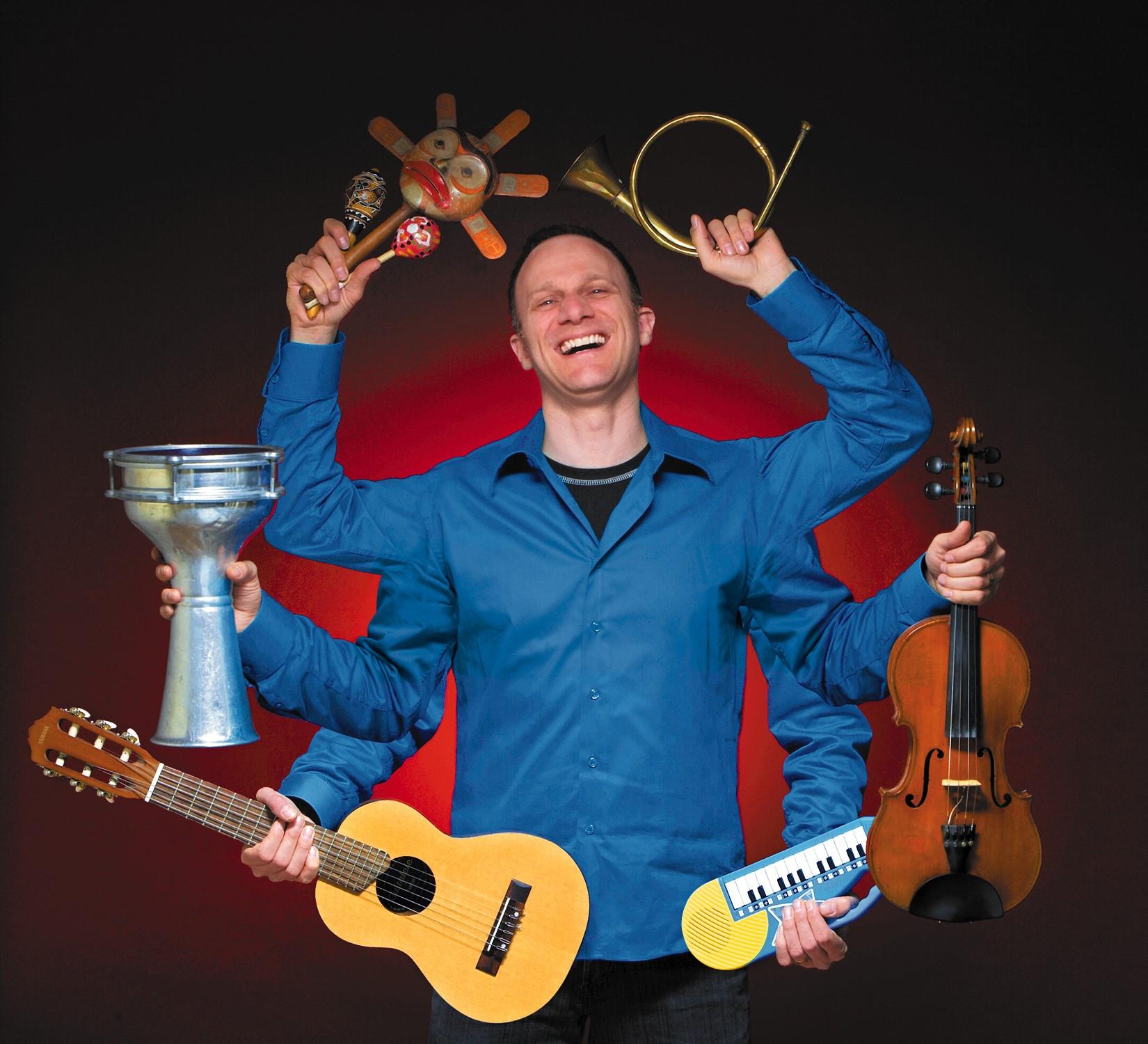 Person holding many different instruments and smiling