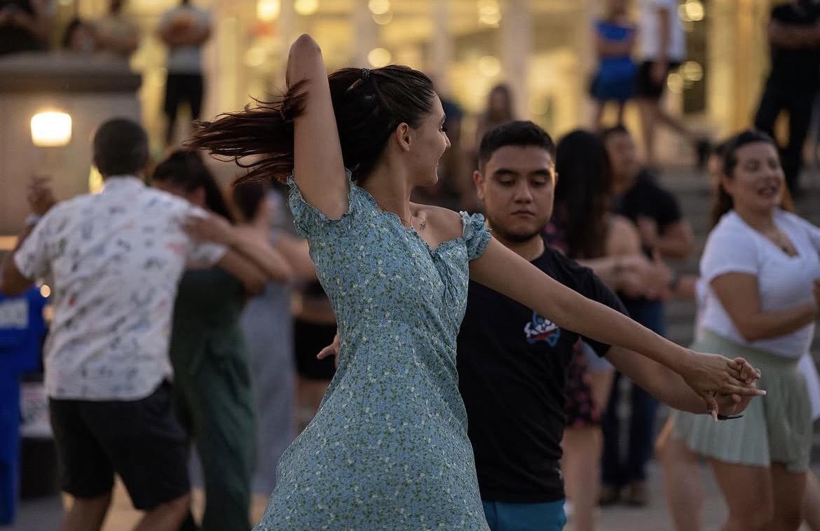 woman in green dress dancing with partner in black shirt